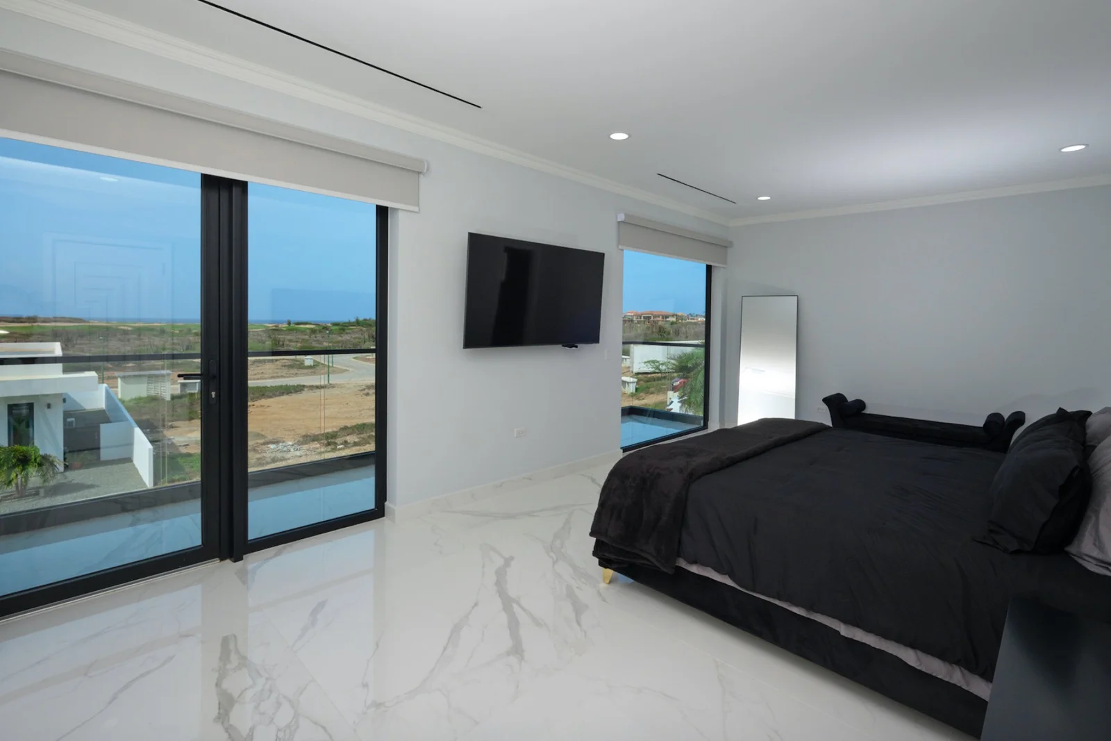Canto di Lama 44 bedroom with charcoal linens and broad Caribbean-facing windows — original listing photograph